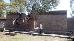 Workers finishing the front cement block wall