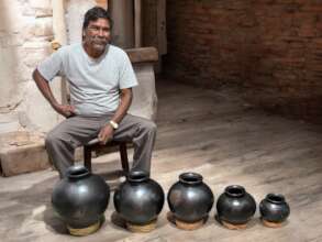 Pedro showing the sizes of pots that he handmakes.