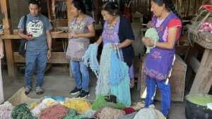 The women showing Will their colored yarn.