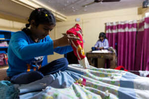 Manisha dumping out a stocking on her bed.
