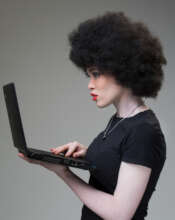 A photo of a young lady holding a laptop.