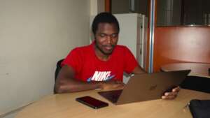 An image of Elvis, seated and using a Macbook.