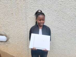 Brenda is smiling and holding a Macbook box.