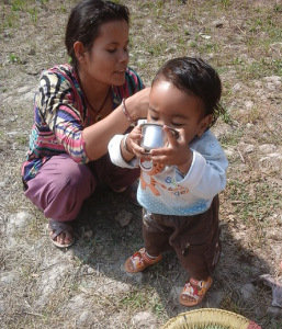 A small child drinking water from the filter