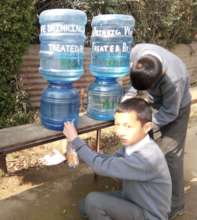 Children using jar and dispenser for water