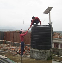 Students on the roof of the school adding WATAsol
