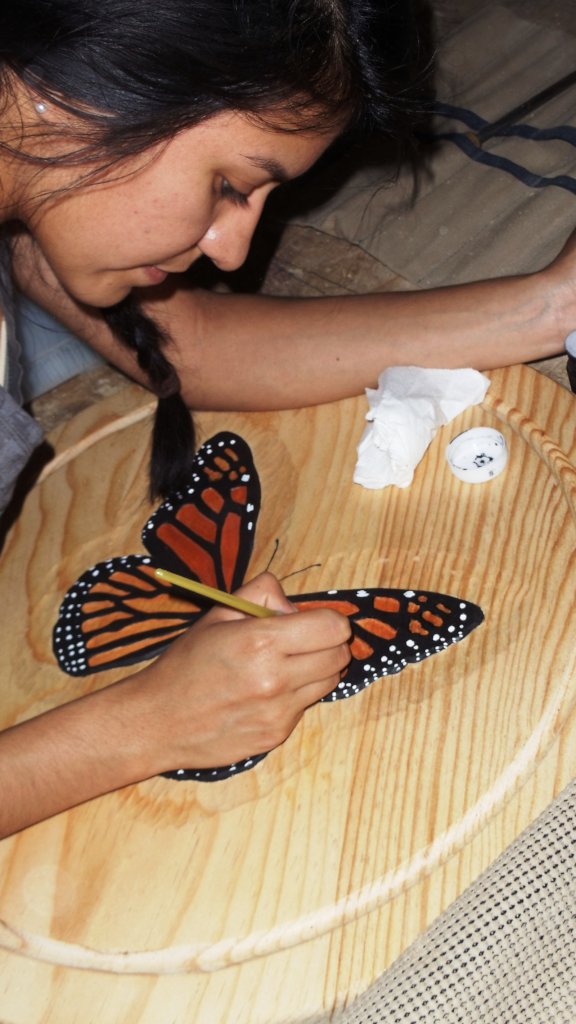Erica Painting a Monarch Carved Butterfly