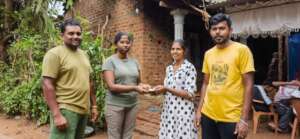 Handing a cash donation to our caretaker's family
