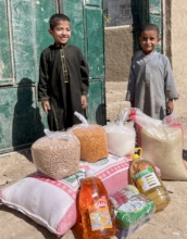 Afghan boys receiving food aid for their family