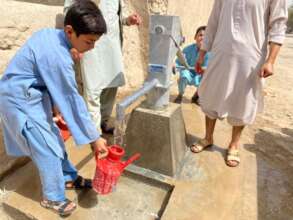 Afghan boy using the new hand pump well