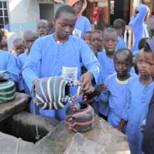 kids lowering pots into water