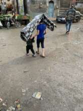 Two young children carrying a carpet in Aleppo