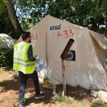 Distributing drinking water at evacuation camps.