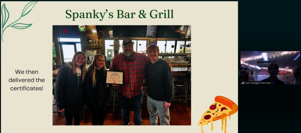 Students delivering Certificate to local business