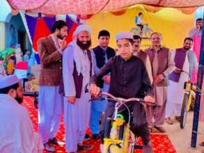 another child receives and rides his bicycle