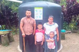 Family with their rainwater harvesting tank.