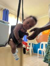 Weighing a child the African way.