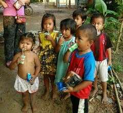 Younger students receiving milk in the slum.