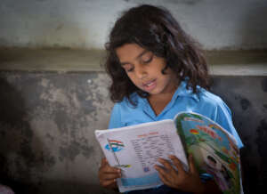 Girl reading  at Apne aap community centre library