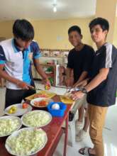 The group prepare a meal in the communal area