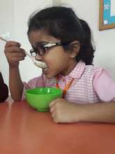 Enjoying her porridge with bananas and dates