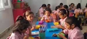 Students enjoying breakfast in colourful utensils.