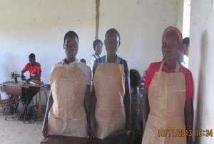Tailoring students show off the aprons made