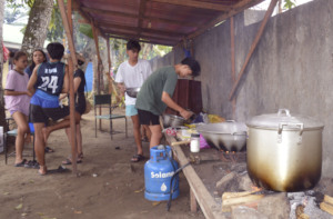Youth volunteers prepare hot meals for evacuees