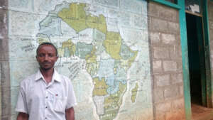 Dergu outside his classroom