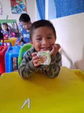 Student holding completed cube craft