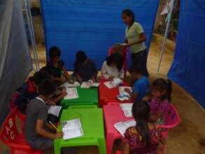 Yoselin working with students on their notebooks