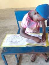 Community learning center student drawing frogs.