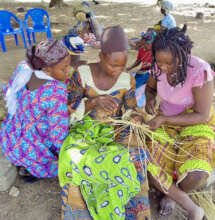 Women learning traditional basket weaving.