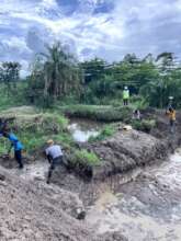 Workers collaborate around a pond