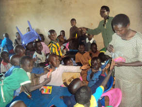 ECD teacher distributing the learning materials