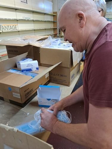 Warehouse Assistant packing PPE for the shipment