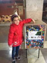 Little girl throwing bottle cap in a box