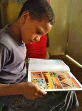 Geremy reading in the Literacy Center