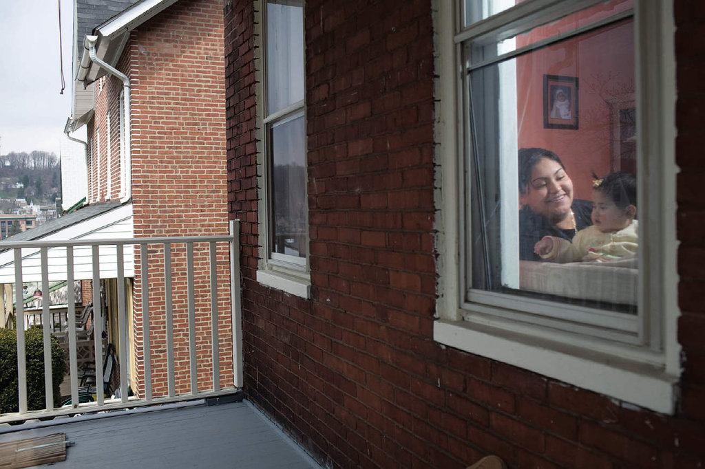 Isabel and her baby through their window