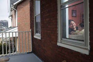 Isabel and her baby through their window