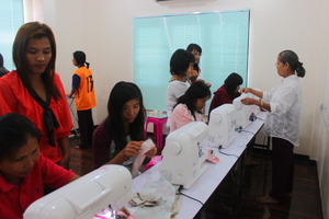 Girls focus on practicing sewing bag.