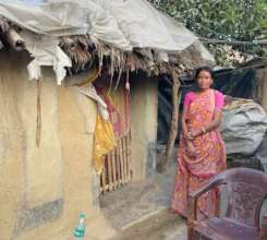 One of our girls' mums. Standing outside her house