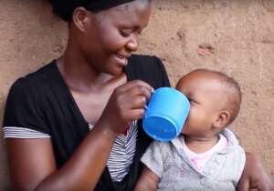 A toddler receiving freshly made soymilk