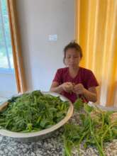 Beneficiary getting the vegetable ready for cookin