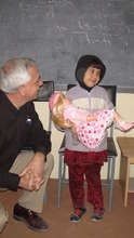 Little Safa smiling as she holds new doll