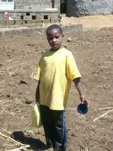 Amos preparing to water plants in the garden