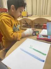A child painting with newly supplied art materials