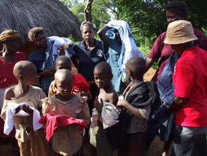 Caregivers distributing clorhing to poor kids