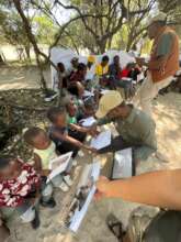 EfA staff assists students with their worksheets