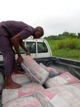 Contracted worker standing over the cement bags.